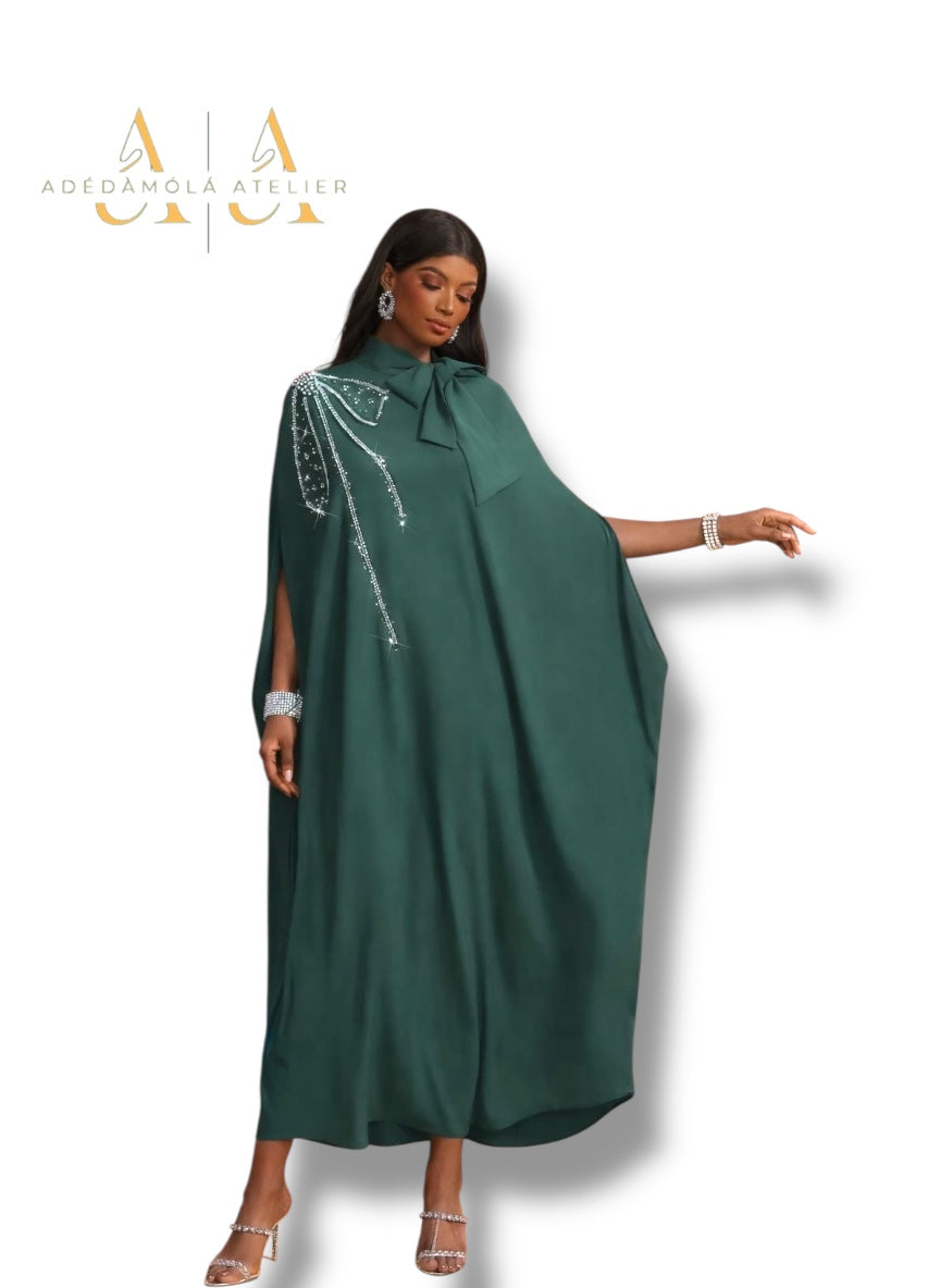 Woman wearing a green dress with silver embellishments on a white background