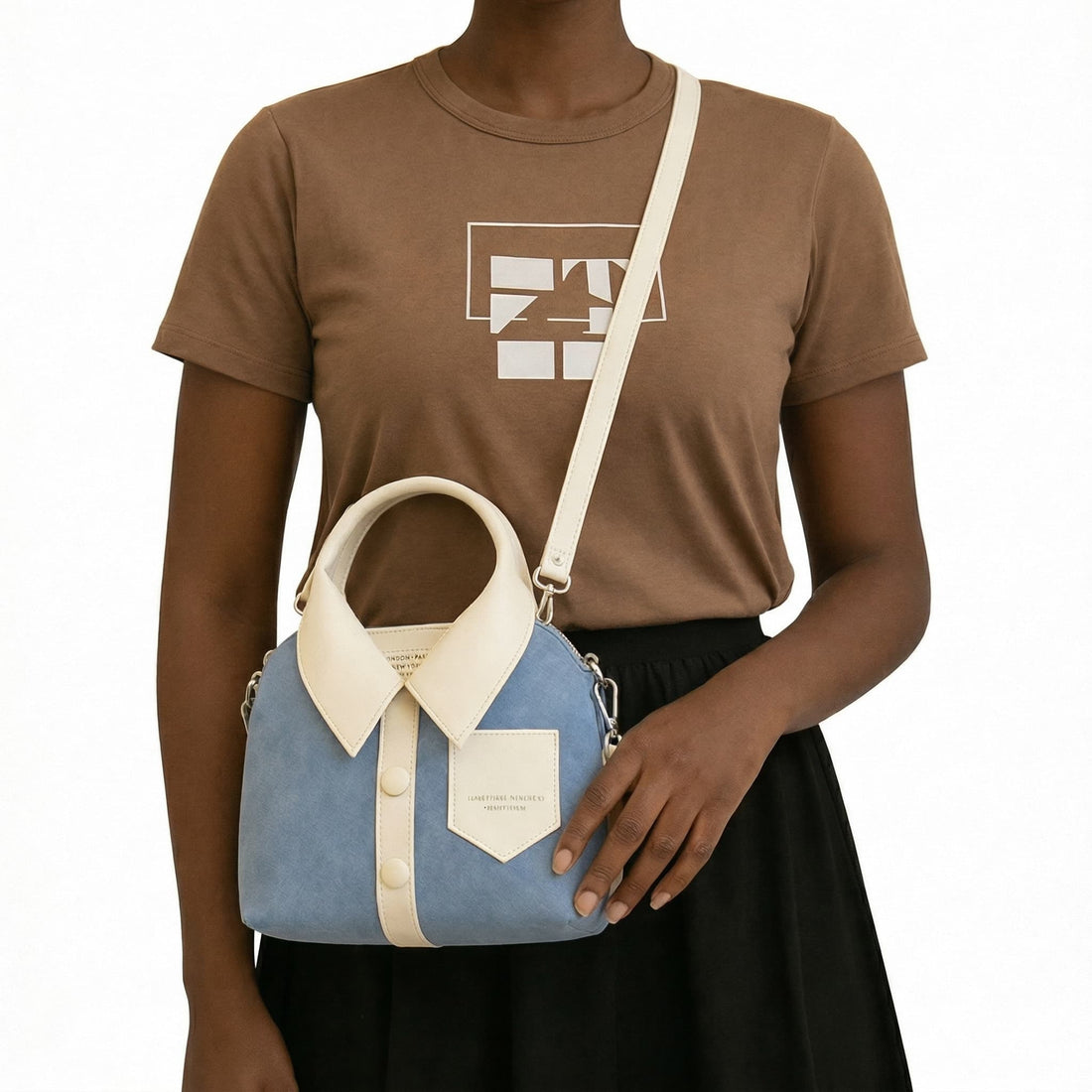 Person holding a blue and beige handbag against a white background