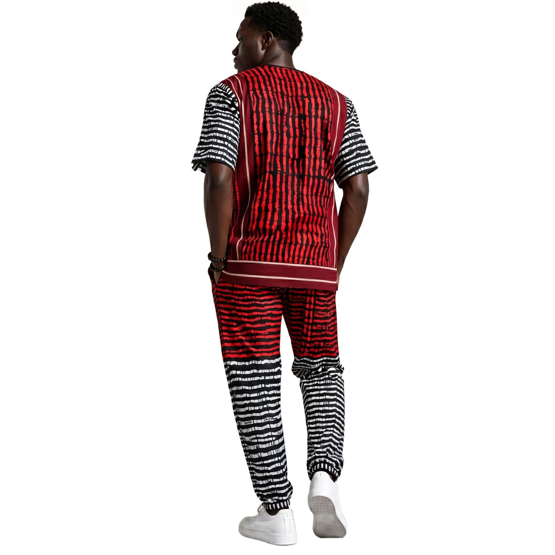 Man wearing a black and white patterned outfit with red accents on a white background