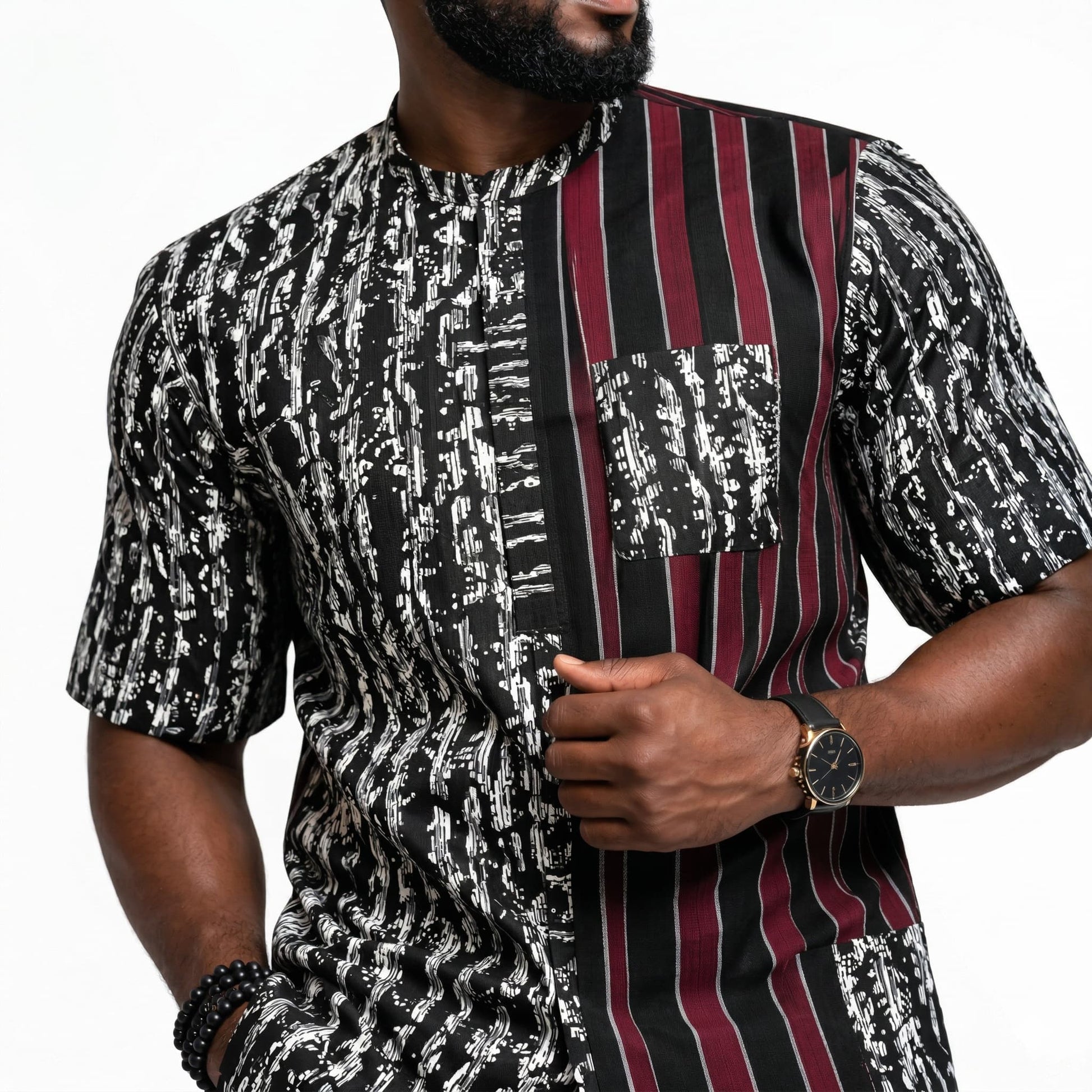 Man wearing a black and white patterned shirt with a maroon and black striped tie on a white background