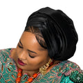 Woman wearing a black headscarf and colorful traditional outfit on a white background