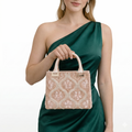 Woman holding a beaded handbag wearing a green dress on a white background