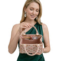 Woman holding a decorative handbag with makeup items on a white background