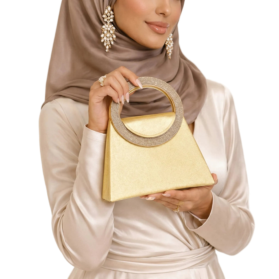 Woman holding a gold handbag with a plain background