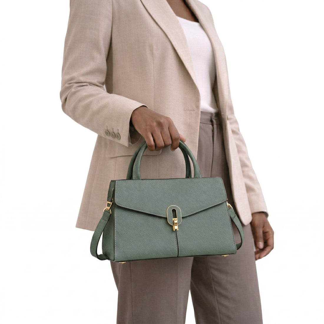 Person holding a green handbag against a white background