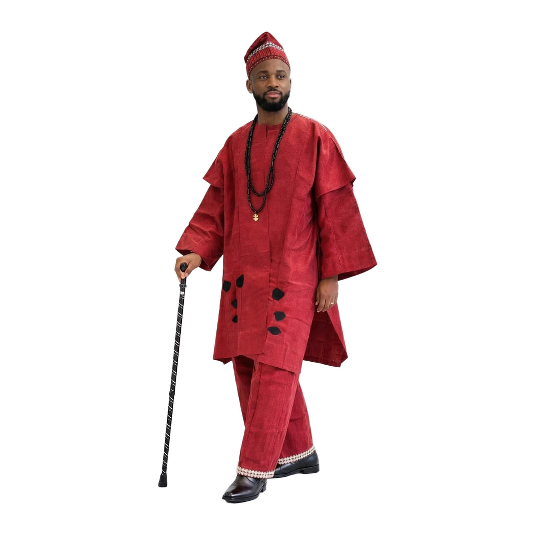 Man wearing a traditional red outfit with a hat, holding a walking stick on a white background