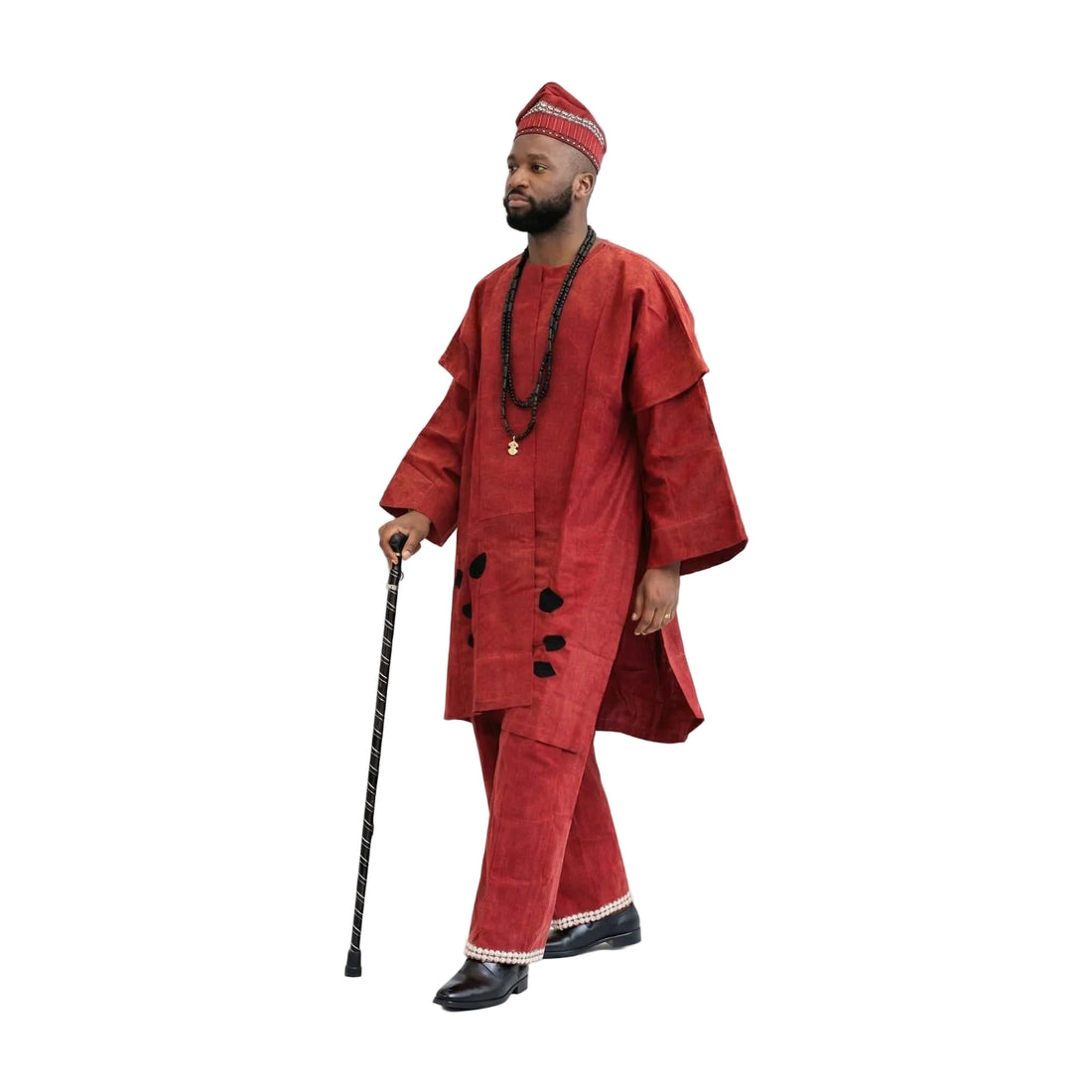 Man wearing a traditional red outfit with a hat, holding a walking stick on a white background