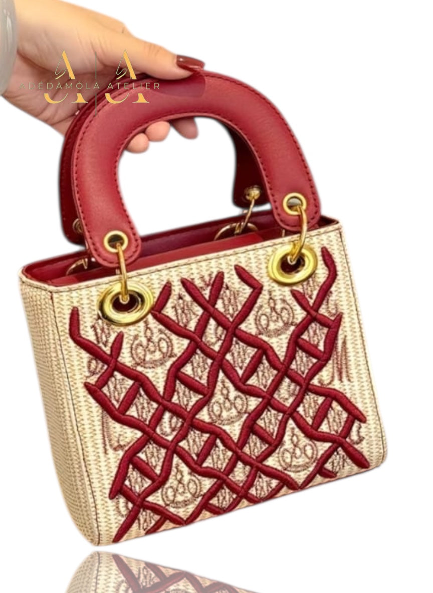 Handbag with black and gold pattern held by a hand