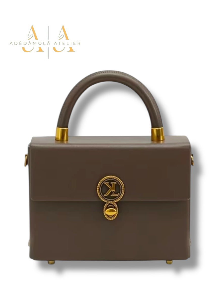 Brown handbag with gold accents on a white background