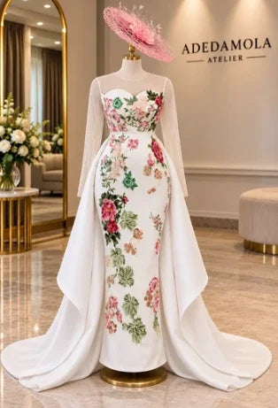 Final look: an ivory floral occasion gown on a mannequin, with sheer sleeves and a flowing train.