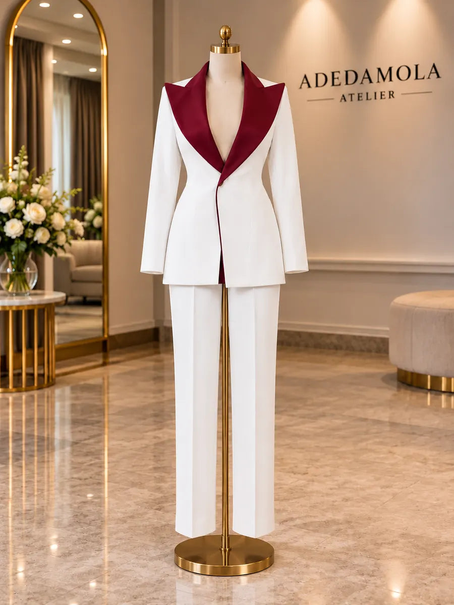 Full-length tailored white tuxedo with split black and burgundy contrast lapel