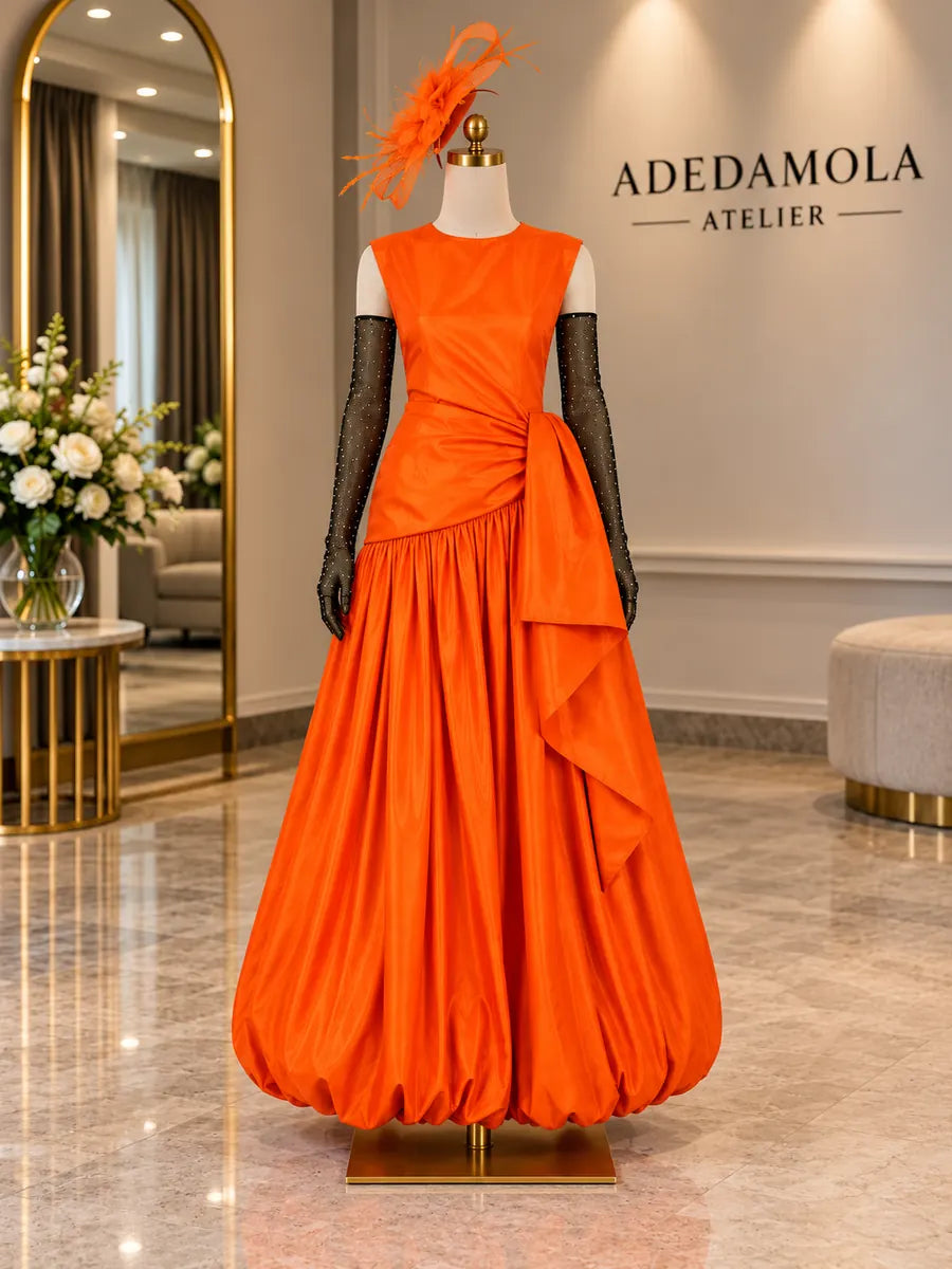 Full-length marigold orange taffeta gown with asymmetric bow and matching fascinator