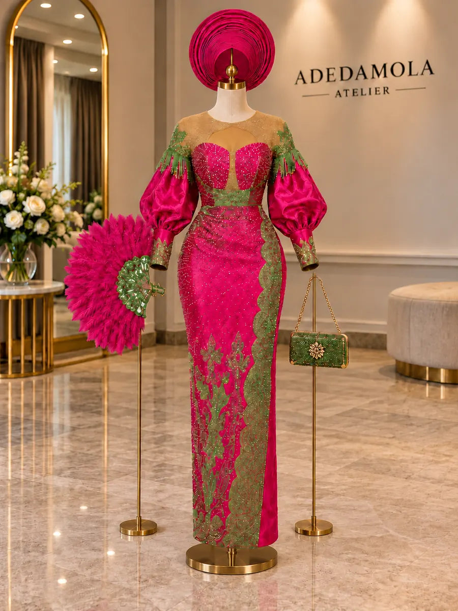 Full-length fuchsia and green traditional beaded gown with matching gele, feathered fan and clutch